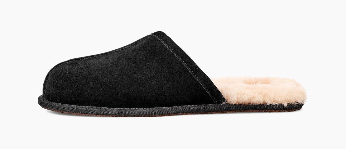 UGG Scuff slippers in black suede with a plush sheepskin lining, side view.