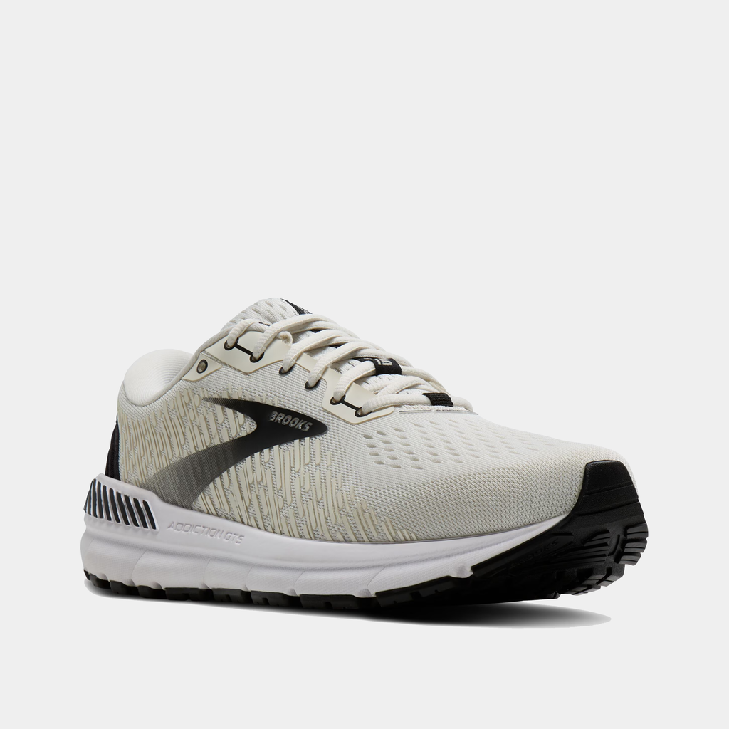 Brooks Addiction GTS 15 running shoes in off-white with black accents, GuideRails support system, and breathable mesh upper, front-angle view.