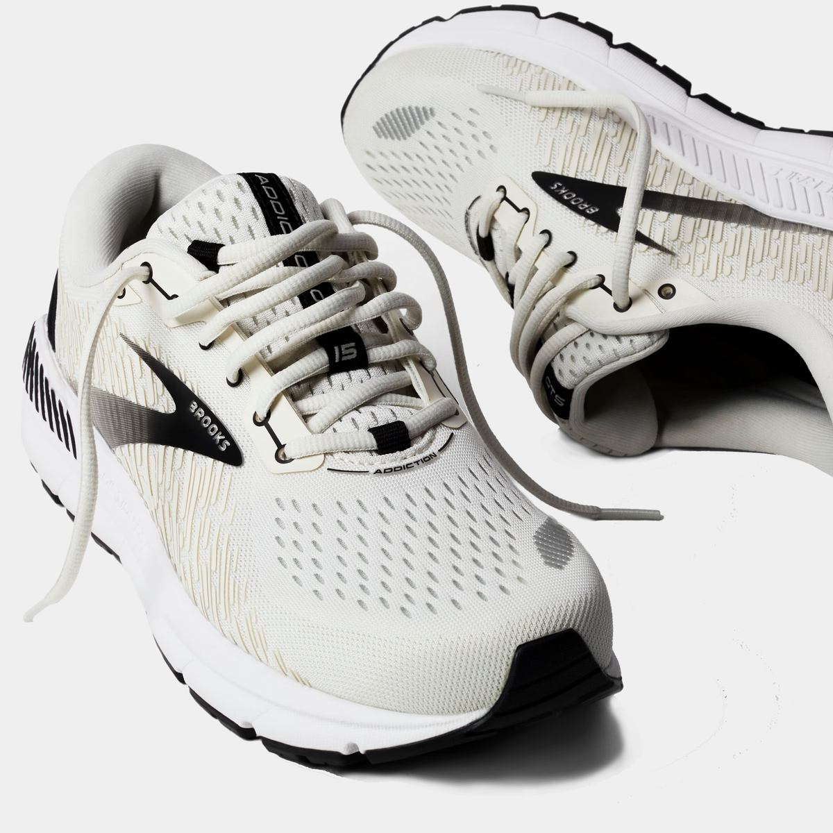 Brooks Addiction GTS 15 running shoes in white with black accents, engineered mesh upper, and GuideRails support system, angled front view.