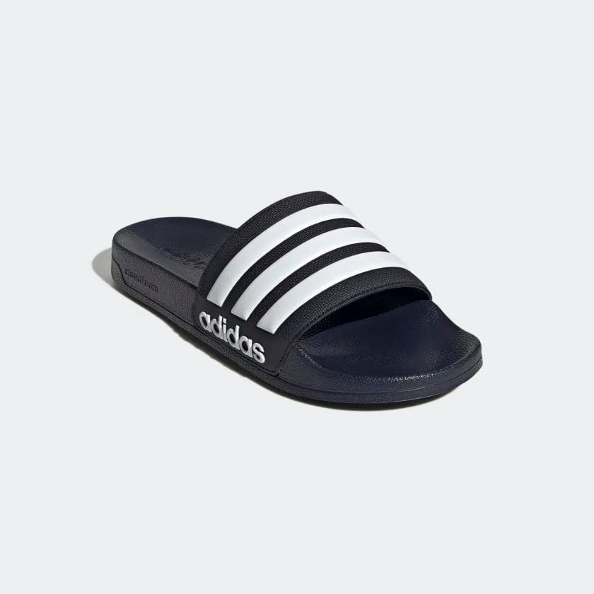 Adidas Adilette Shower Slides in navy blue with white striped strap and embossed logo, angled front side view.