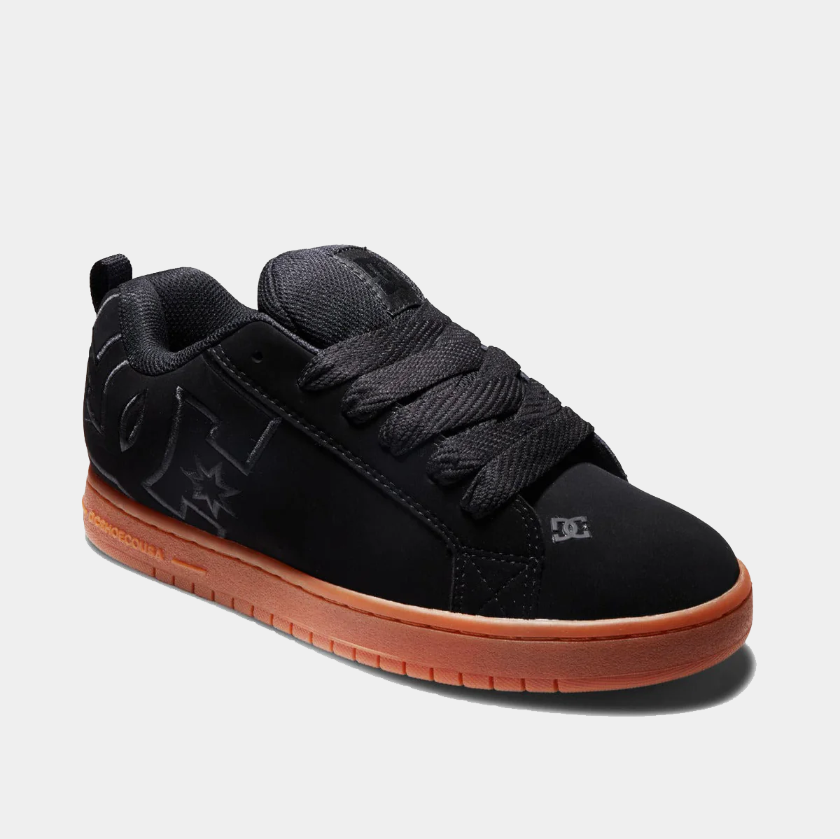 DC Footwear Court Graffik sneakers in black with oversized logo details and gum rubber sole, angled side view.