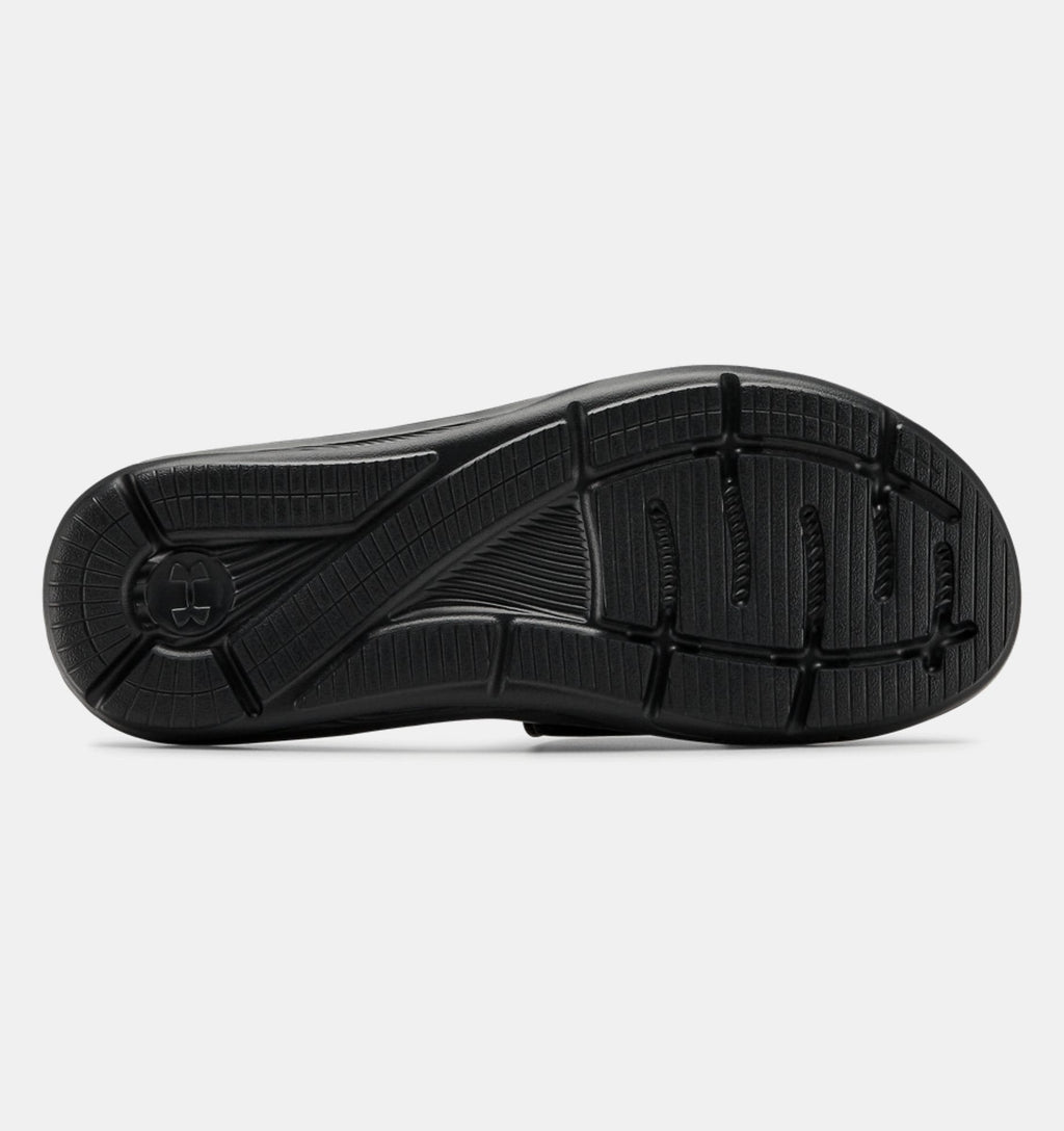 Under Armour Ignite VI SL sandal outsole in black with textured grip pattern and flex grooves, sole/bottom view.