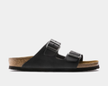 Birkenstock Arizona Oiled Leather sandals in black with adjustable metal buckles and cork footbed, side view.