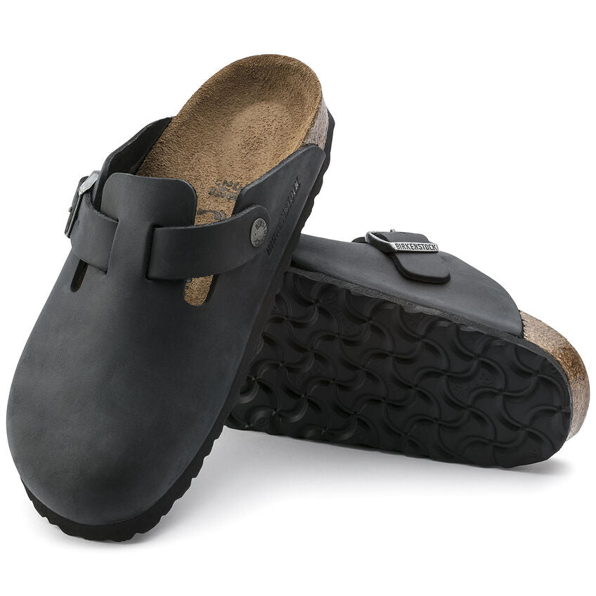 Birkenstock Boston Oiled Leather clogs in black with adjustable strap, cork footbed, and textured outsole, angled view.