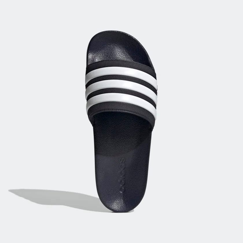 Adidas Adilette Shower Slides in navy blue with white striped band and textured footbed, top view.