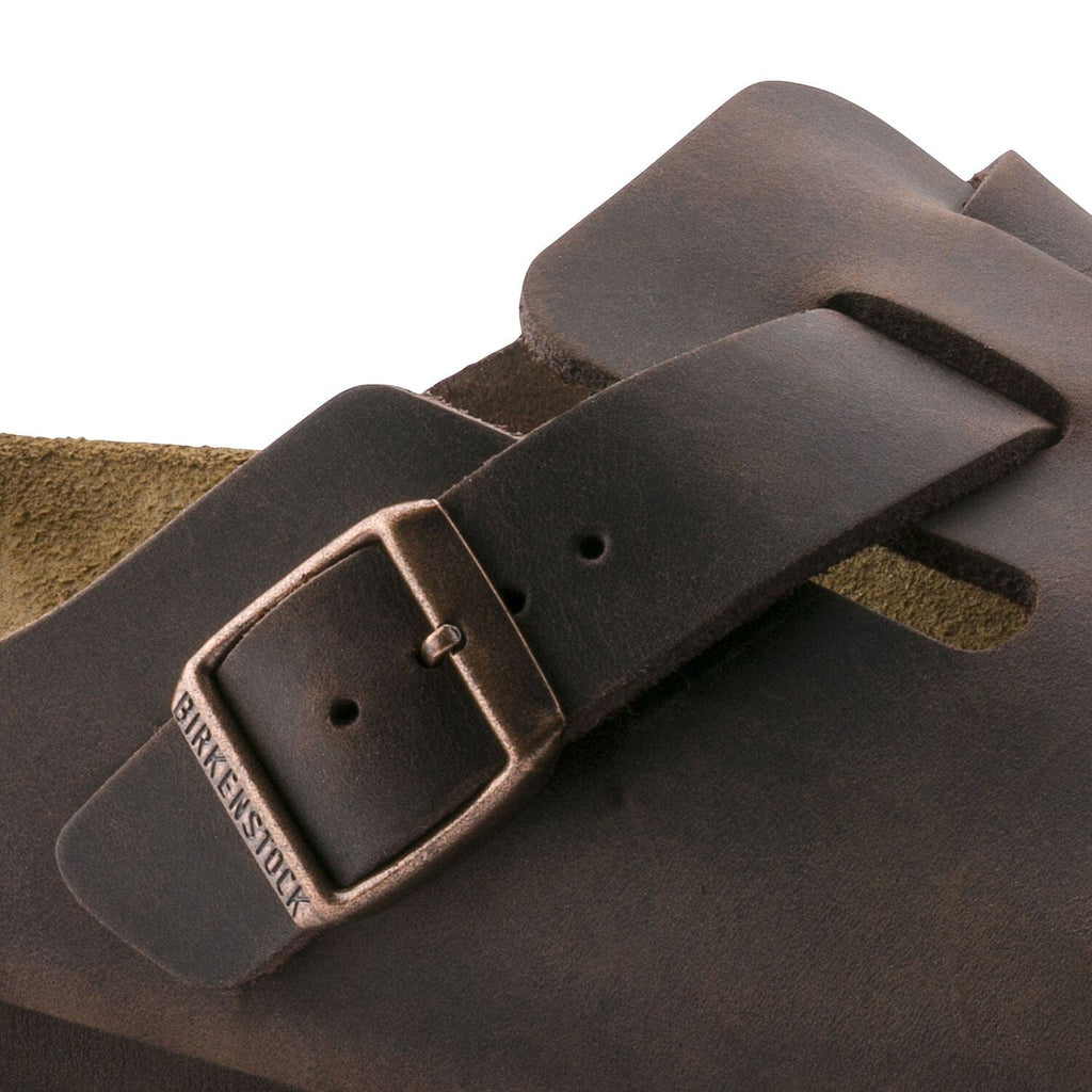 Birkenstock Boston Oiled Leather clogs in dark brown with adjustable buckle detail and suede lining, close-up view.