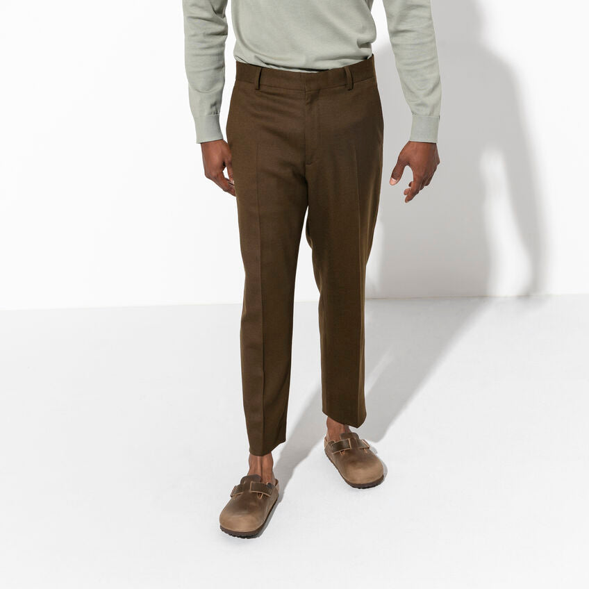 Birkenstock Boston Oiled Leather clogs in brown with adjustable strap and contoured cork footbed, worn by a person standing.