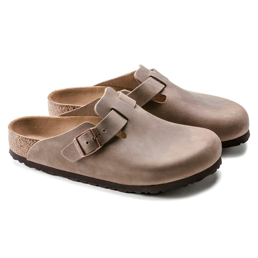 Birkenstock Boston Oiled Leather clogs in taupe brown with adjustable buckle strap and cork footbed, angled front view.