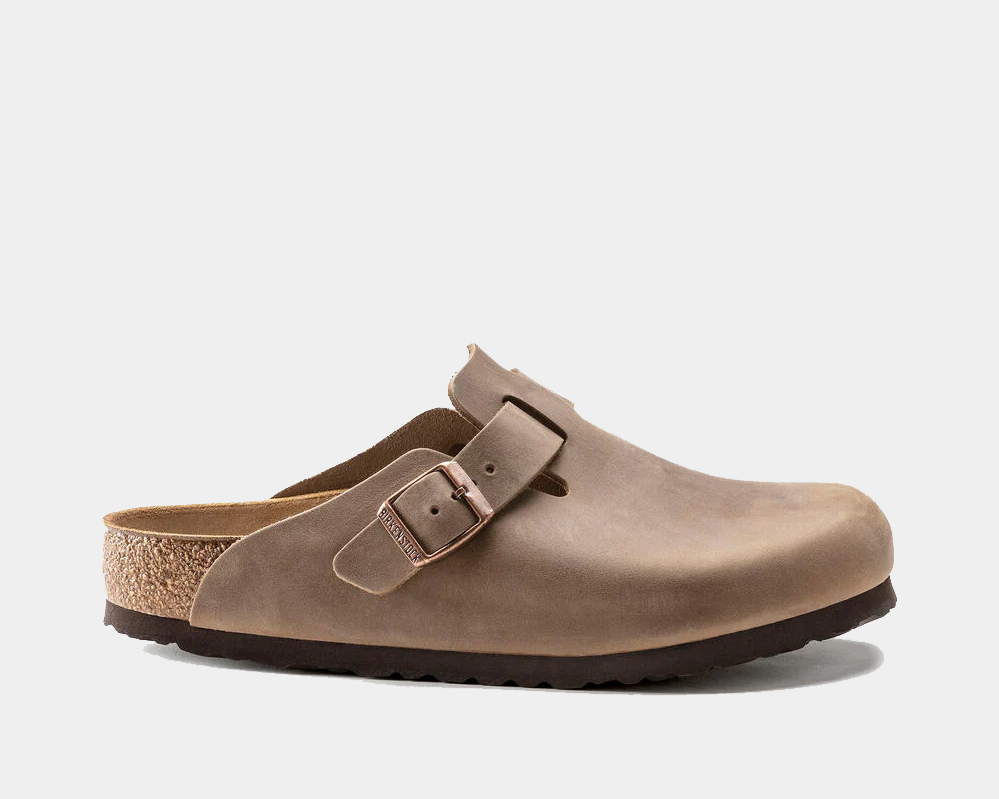 Birkenstock Boston Oiled Leather clogs in brown with adjustable strap, cork footbed, and black rubber sole, side view.