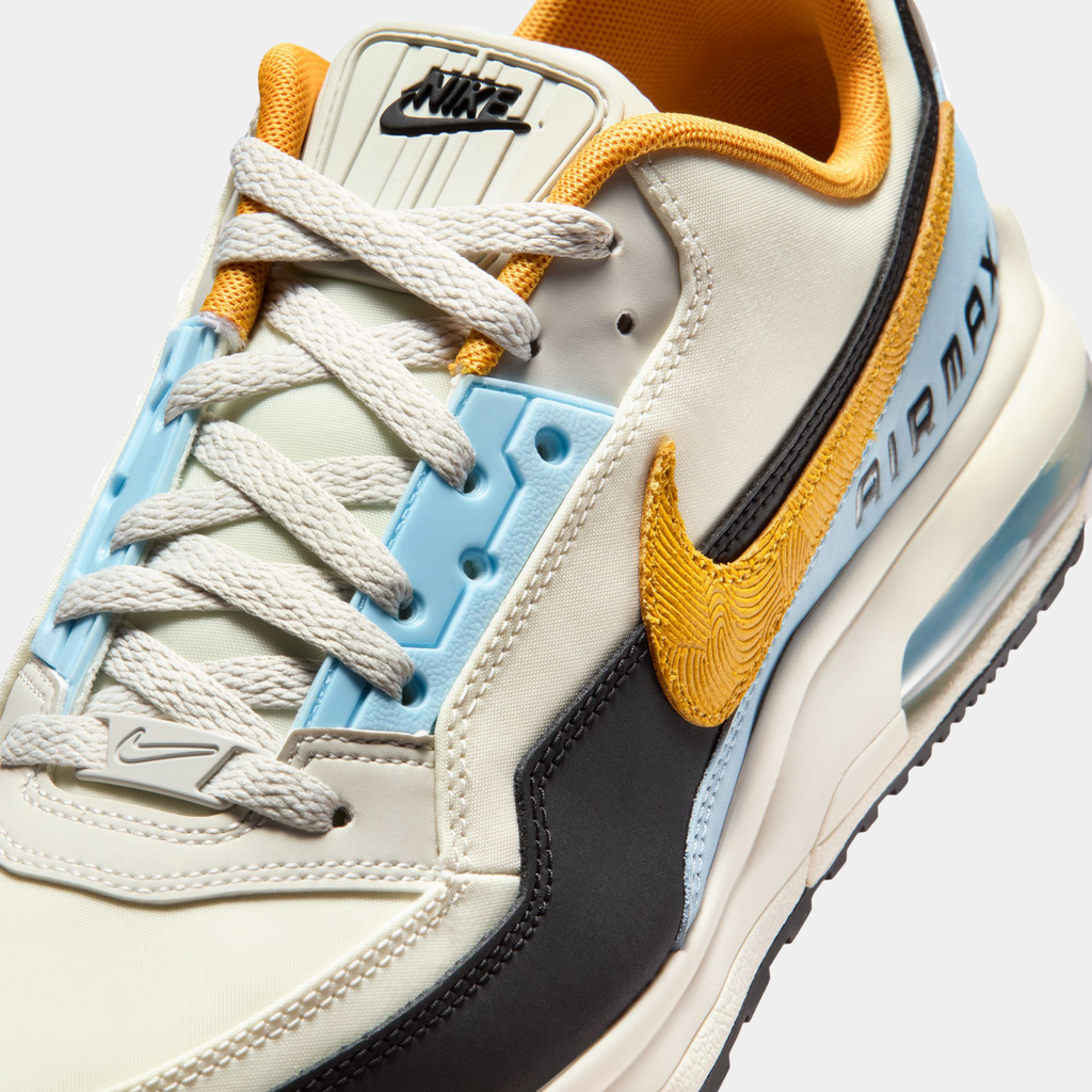 Close-up of a Nike sneaker with beige, yellow, and black design elements on a white background