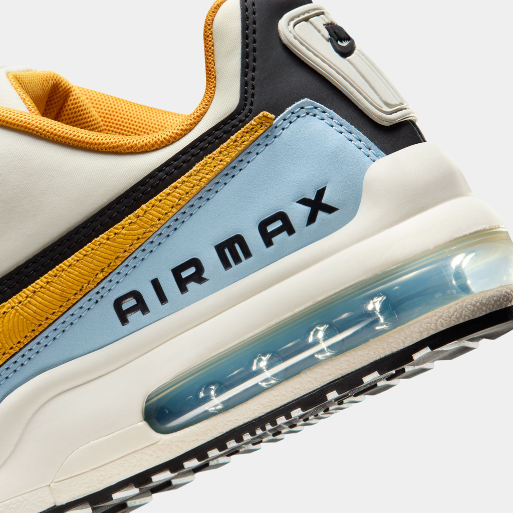 Close-up of a Nike Air Max sneaker with yellow, black, and blue accents on a white background.