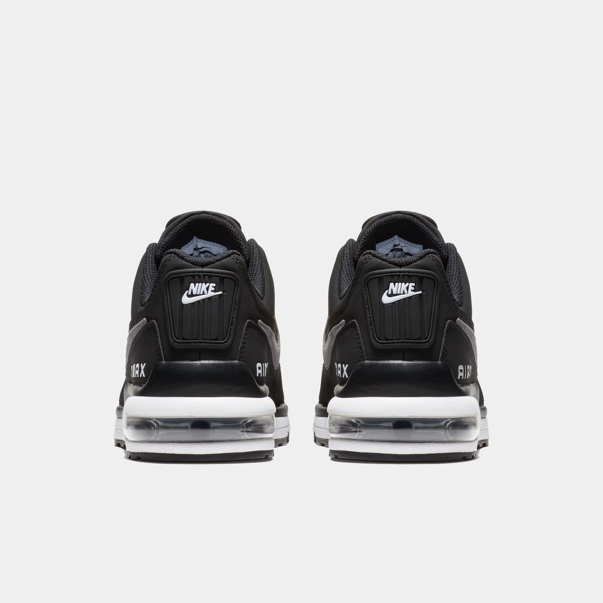 Black Nike sneakers with clear air cushion sole on a white background
