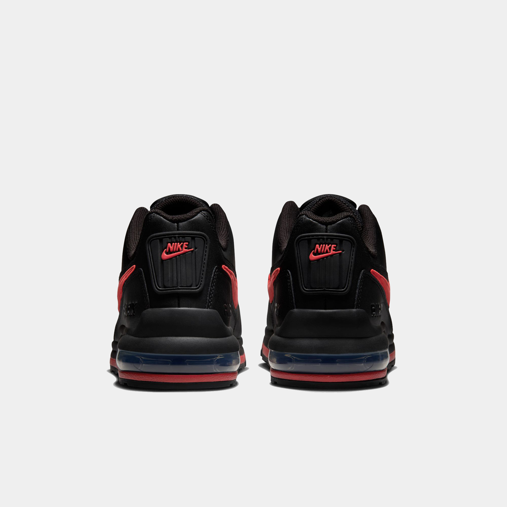 Black Nike sneakers with red accents on a white background