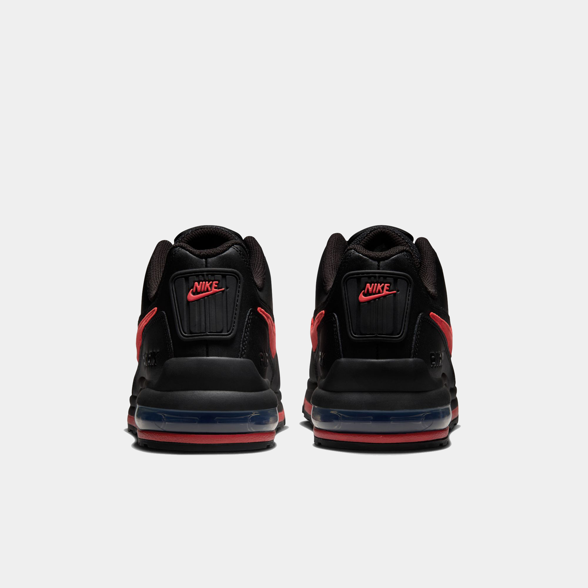 Black Nike sneakers with red accents on a white background