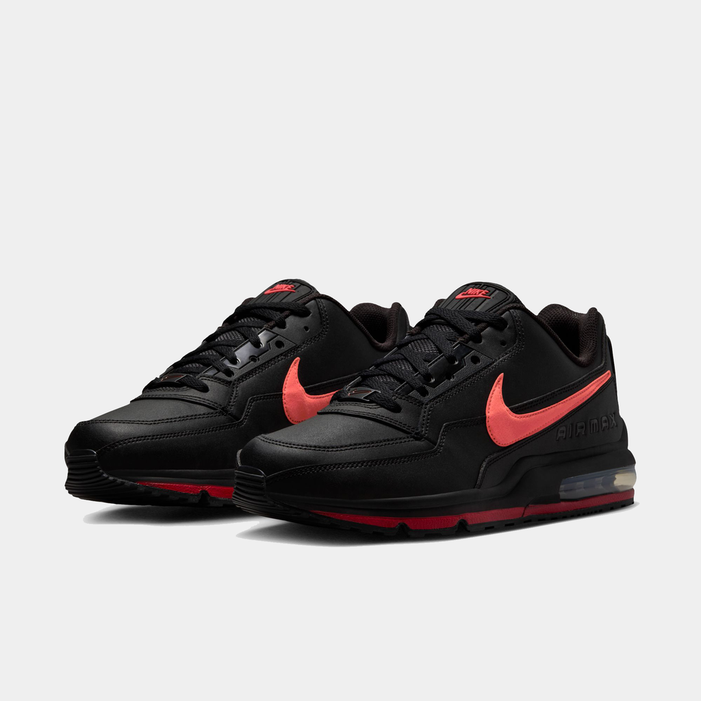 Black sneakers with red accents on a light gray background