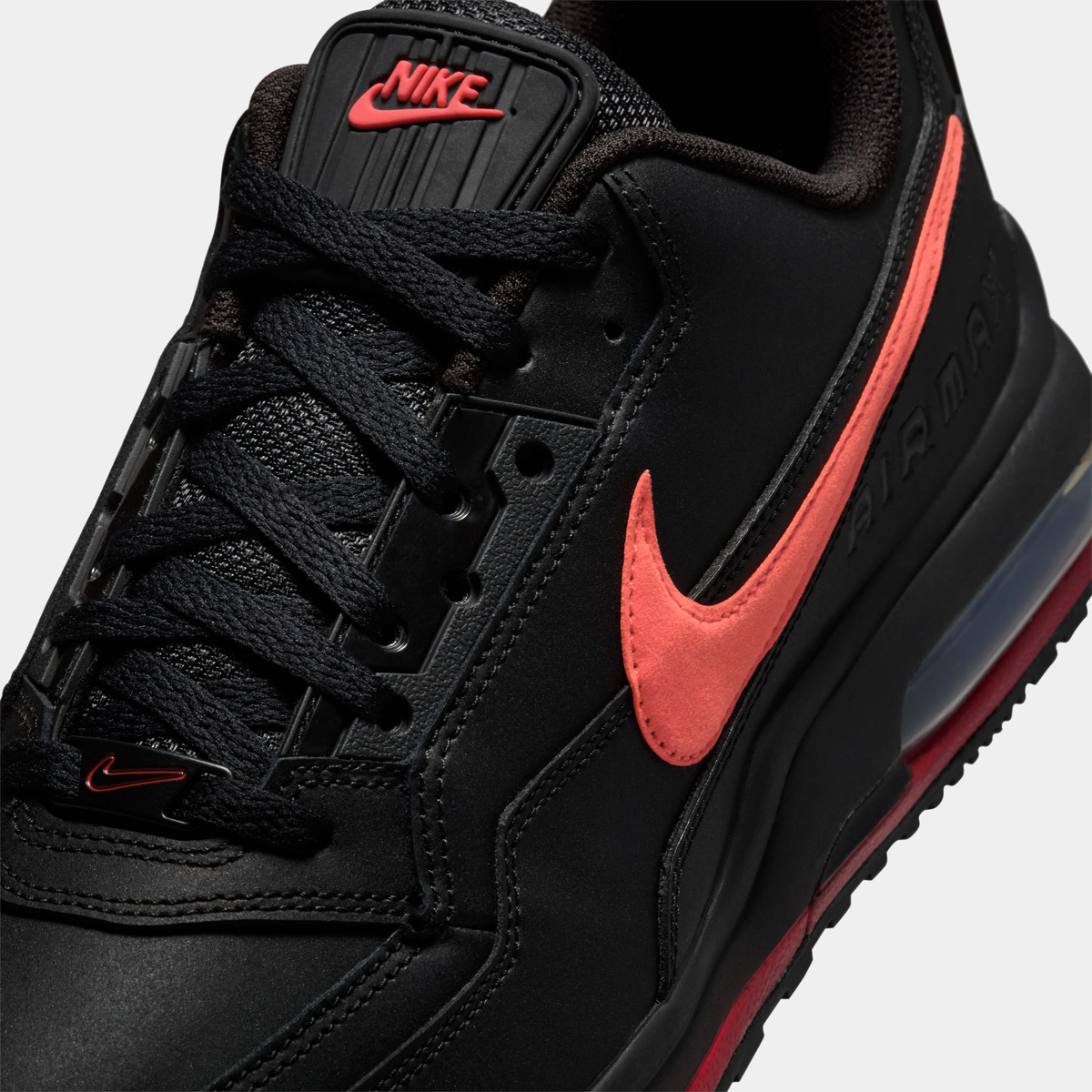 Black sneaker with red Nike logo on a light gray background