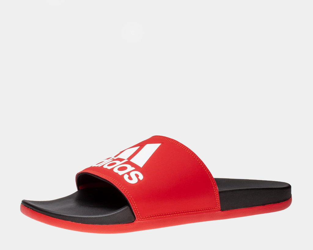 Adidas Adilette Comfort Slides in red with bold white logo and black cushioned footbed, side angle view.