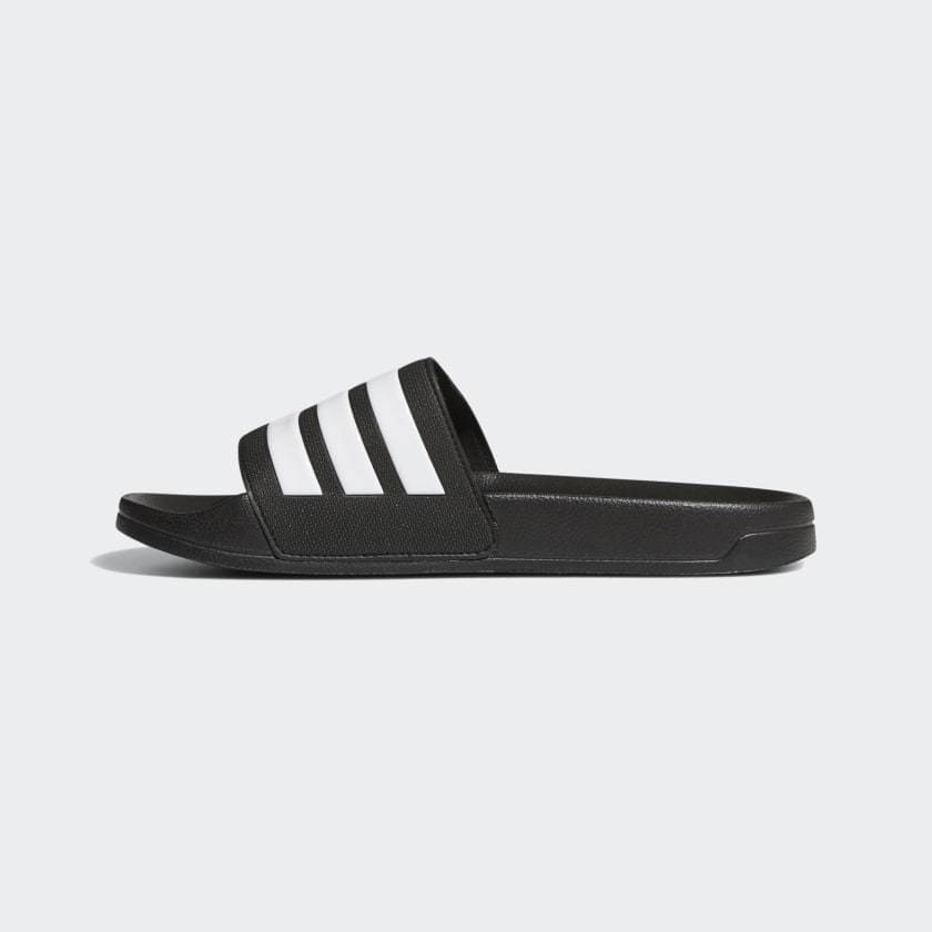 Adidas Adilette Shower Slides in black with white signature three-stripe design, side view showing slip-on style and textured footbed.