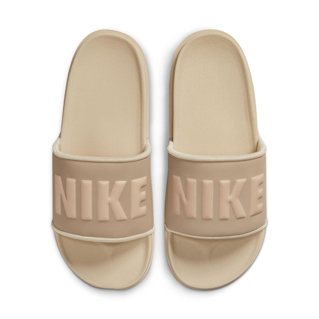 Nike Offcourt Slide sandals in beige with textured footbed and bold Nike logo on wide strap, top view.