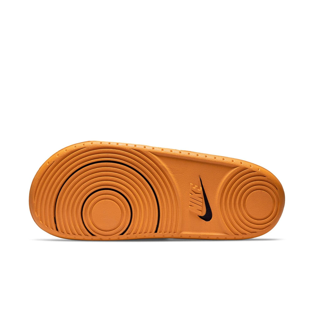 Nike Offcourt Slide sandal outsole in bright orange rubber featuring circular textured patterns and black Nike logo.