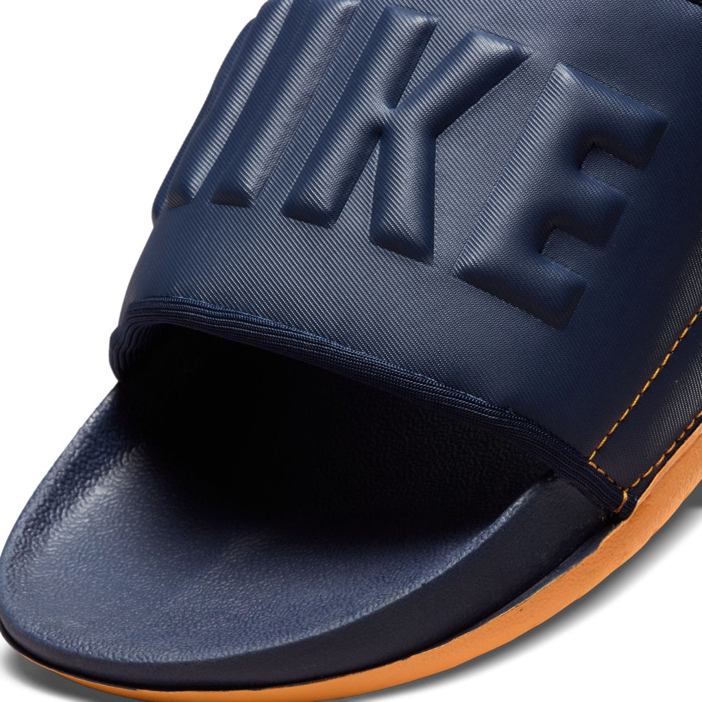 Nike Offcourt Slide sandals in navy blue with textured strap and embossed logo, close-up front view.