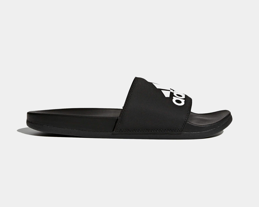Adidas Adilette Comfort Slides in black with logo-adorned synthetic strap and cushioned footbed, side view.