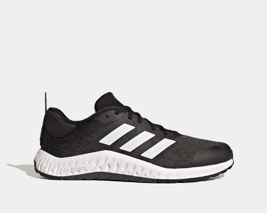 Adidas Everyset Trainer shoes in black with white accents, featuring mesh upper, cushioned midsole, and dual-density outsole, side view.