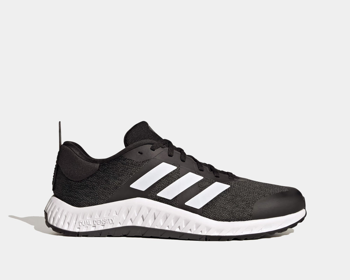 Adidas Everyset Trainer shoes in black with white accents, featuring mesh upper, cushioned midsole, and dual-density outsole, side view.