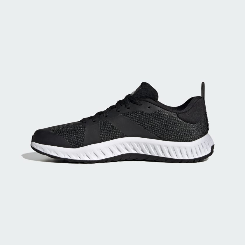 Adidas Everyset Trainer shoes, side view in black with a mesh upper and white cushioned sole featuring textured pattern.
