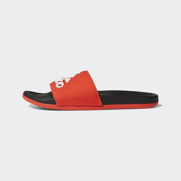 Adidas Adilette Comfort Slides in red with bold white Adidas logo on strap, black footbed, and red outsole, side view.