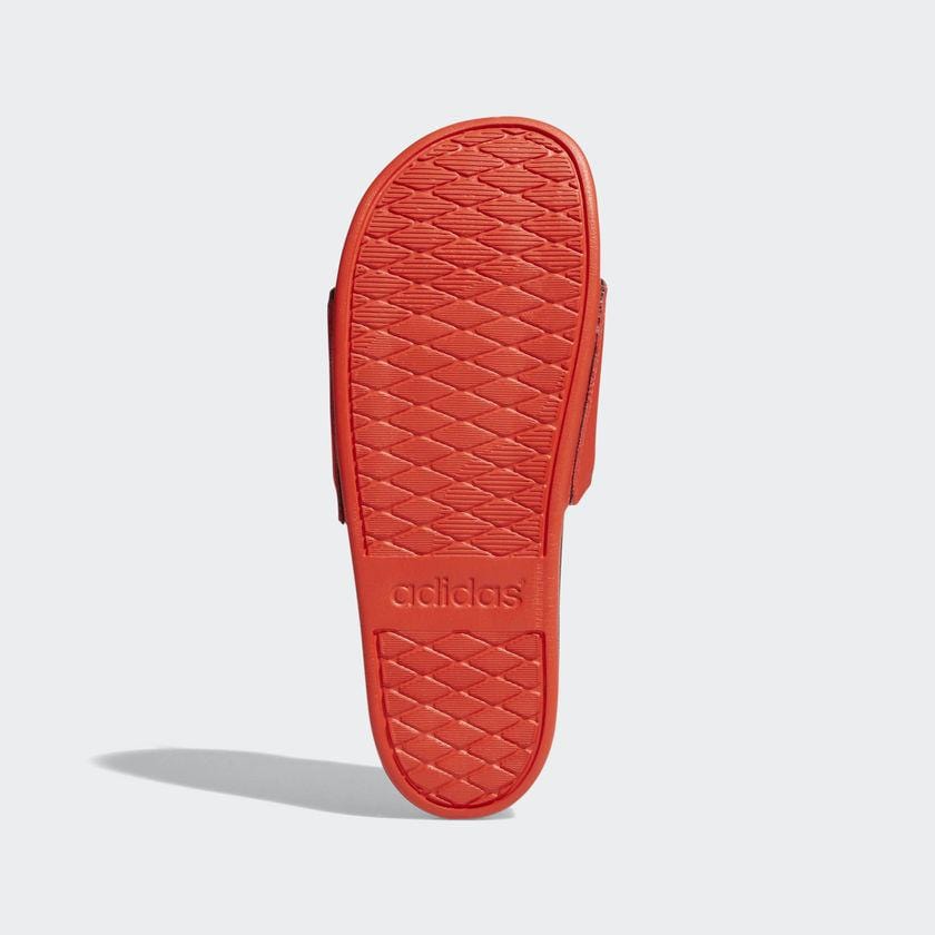 Adidas Adilette Comfort Slides sole view in vibrant red, featuring textured rubber outsole and embossed Adidas branding.