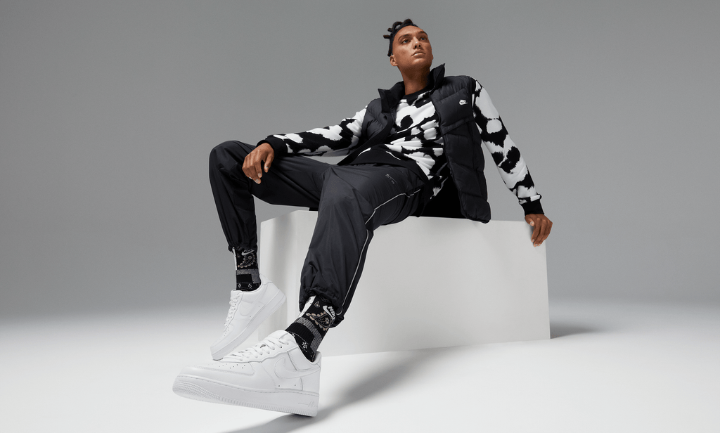 Nike Air Force 1 '07 sneakers in clean white leather design with perforated toe box and signature Swoosh logo, lifestyle setting.