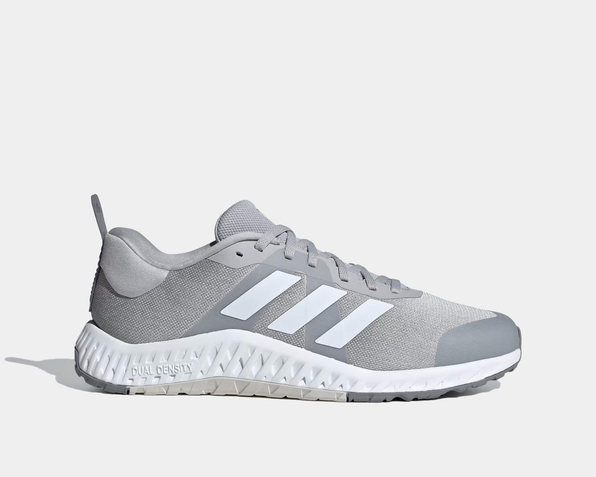 Adidas Everyset Trainer shoes side view in light gray with white accents, mesh upper, and dual-density textured midsole.