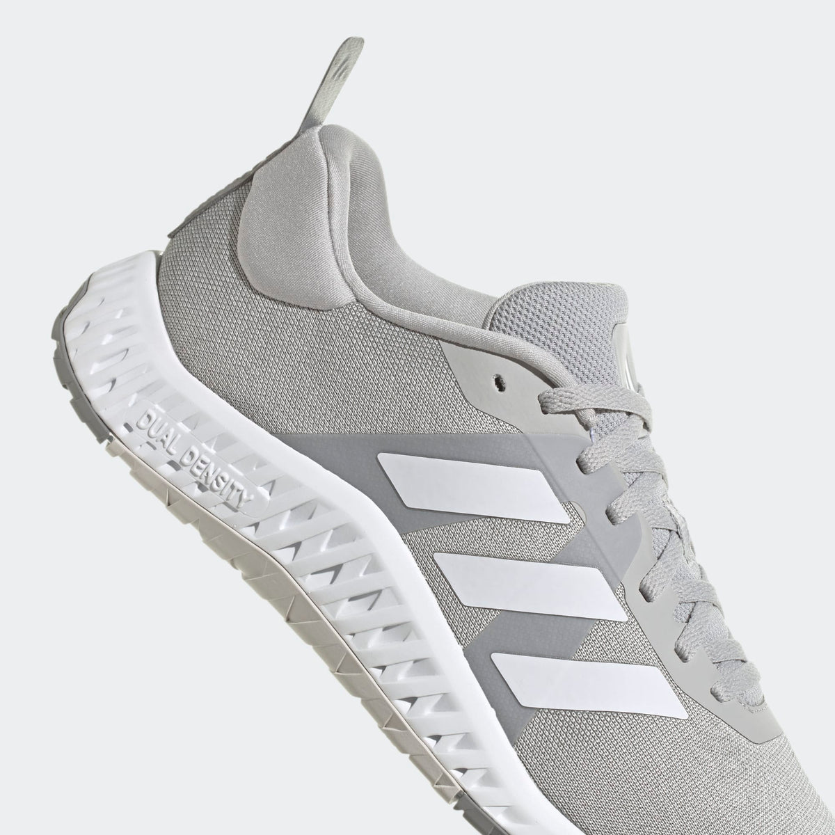 Adidas Everyset Trainer sneakers in light gray with mesh upper, white Three Stripe overlays, and Dual Density outsole, side view.