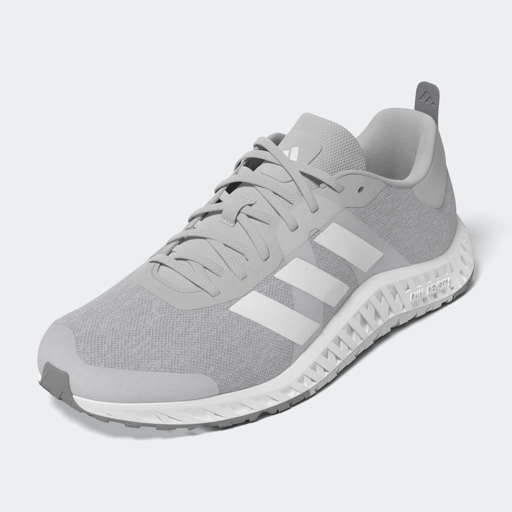 Adidas Everyset Trainer training shoes in light gray with white accents, mesh upper, lace-up design, and textured outsole, front-side view.