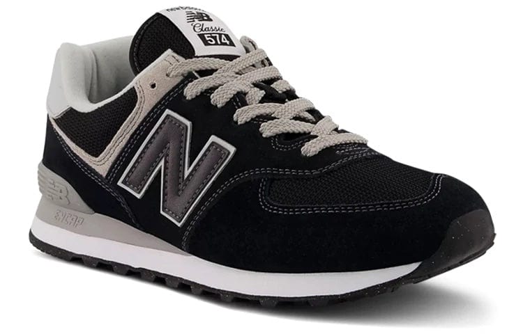 New Balance 574 Core sneakers in black and gray with suede and mesh upper, leather "N" logo, and rubber outsole, angled front-side view.