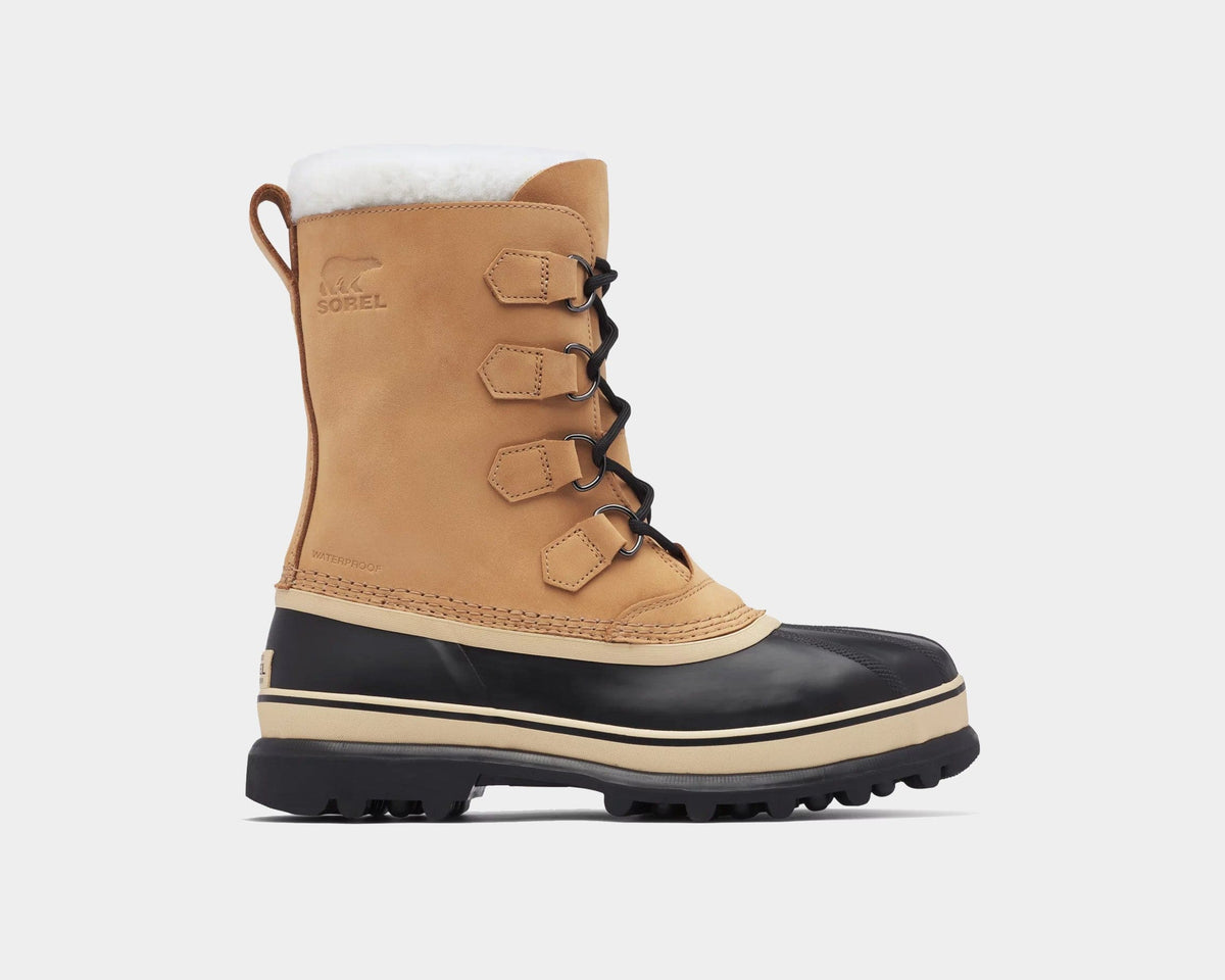 Sorel Caribou Winter Boots in tan suede with black rubber shell, sherpa lining, and waterproof construction, side view.