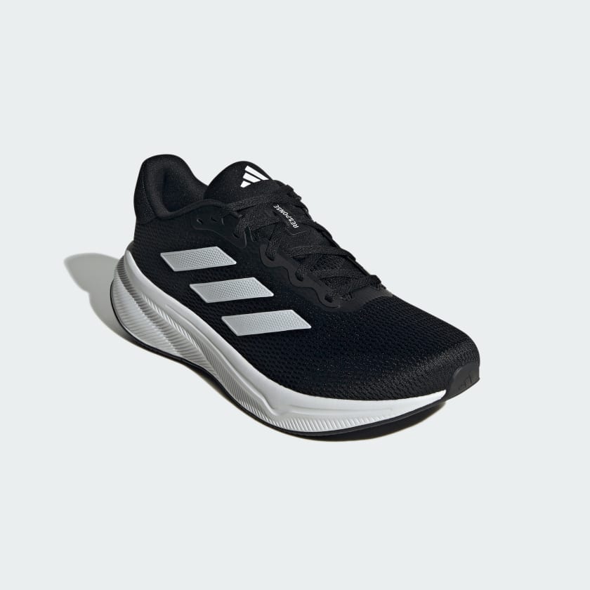 Adidas Response running shoes in black mesh with white sole and three-stripe design, angled front view