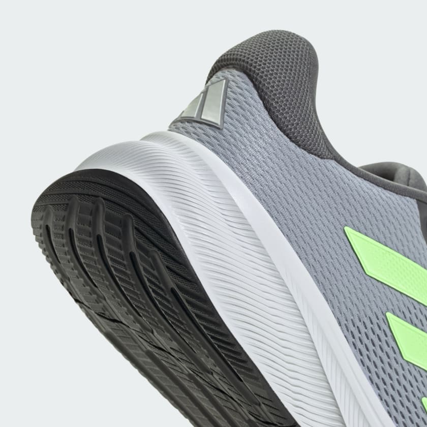 Adidas Response running shoes in gray with neon green accents, black outsole, and textured mesh upper, angled view of heel and sole.