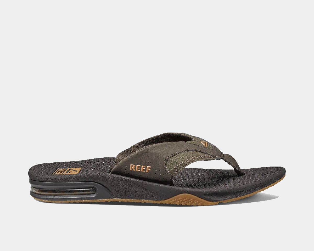 Reef Fanning Flip Flops in brown and black with synthetic strap, textured footbed, and air-cushioned heel, side view.