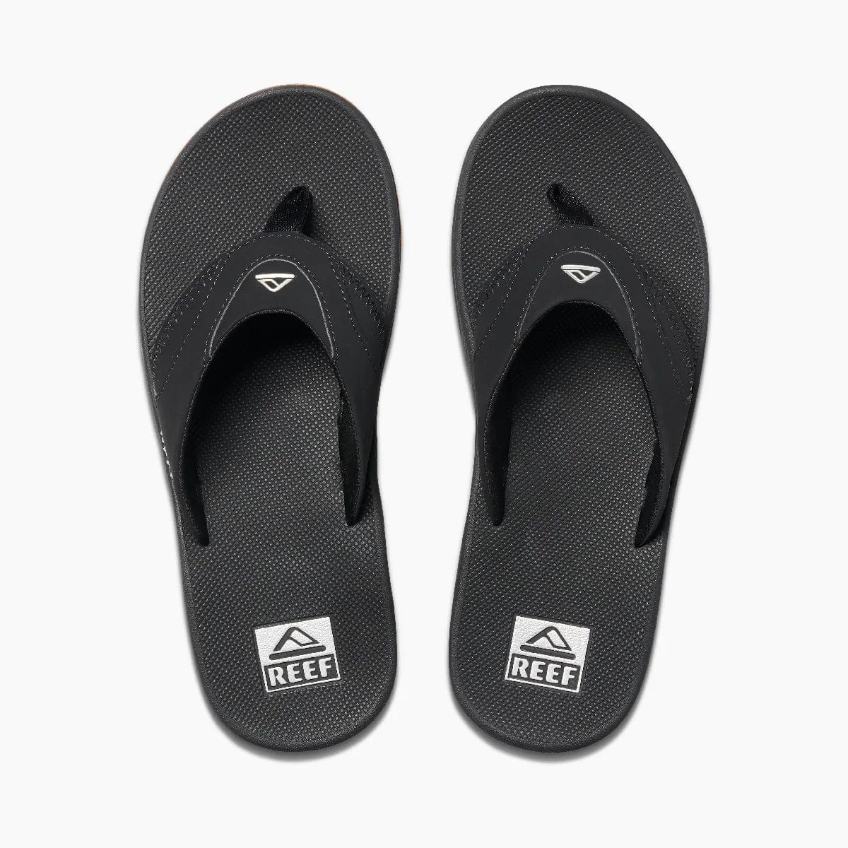 Reef Fanning Flip Flops in black with textured footbed, logo detail on straps, and built-in bottle opener, top view.
