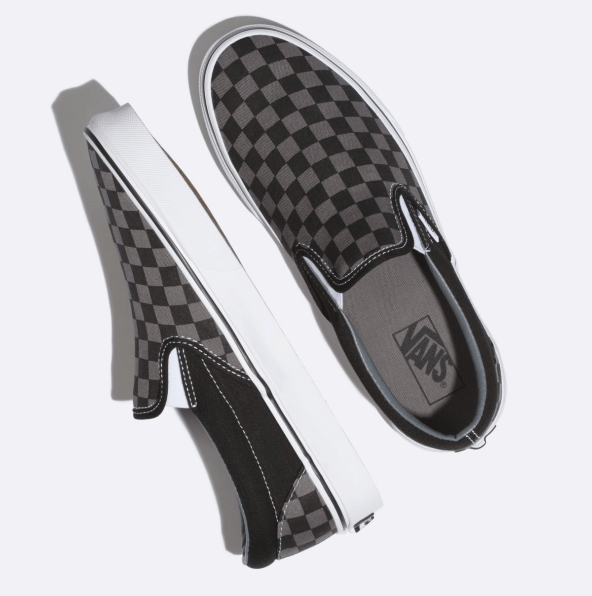 Vans Checkerboard Slip On shoes with black and gray checkered canvas upper, white midsoles, and elastic side accents, top view.