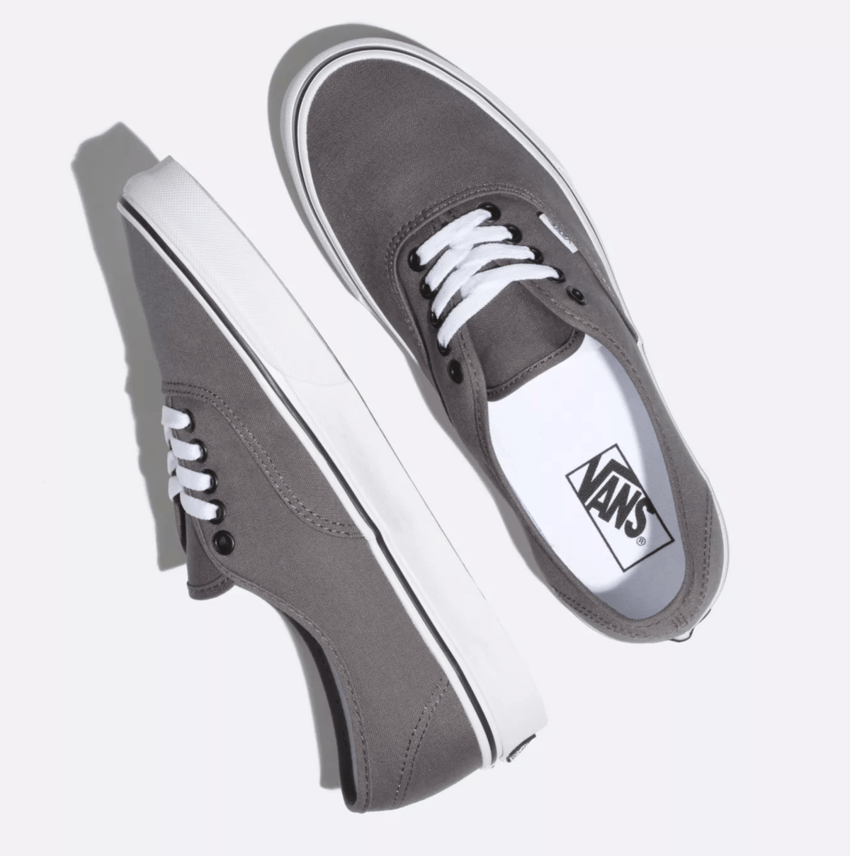 Vans Authentic sneakers in gray canvas with white laces and iconic waffle outsole, top angled view.