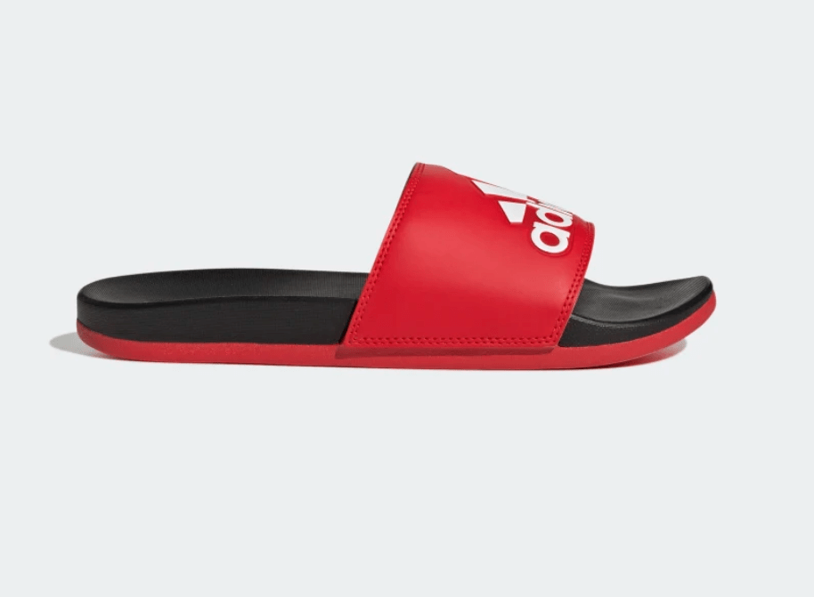 Adidas Adilette Comfort Slides in red with white logo and black footbed, side view showing cushioned sole and slip-on design