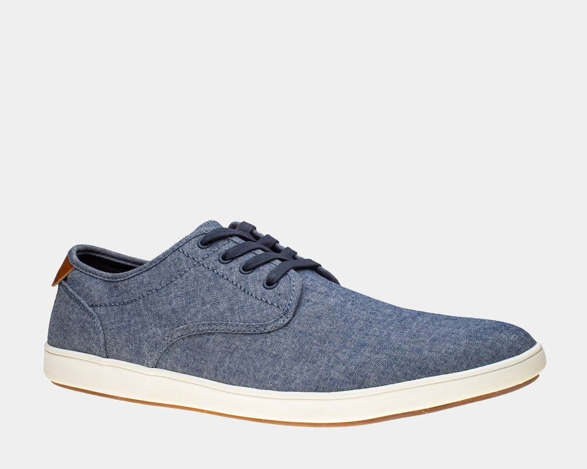 Steve Madden Fenta casual shoes in denim blue with lace-up closure, white rubber sole, and brown heel accent, side view