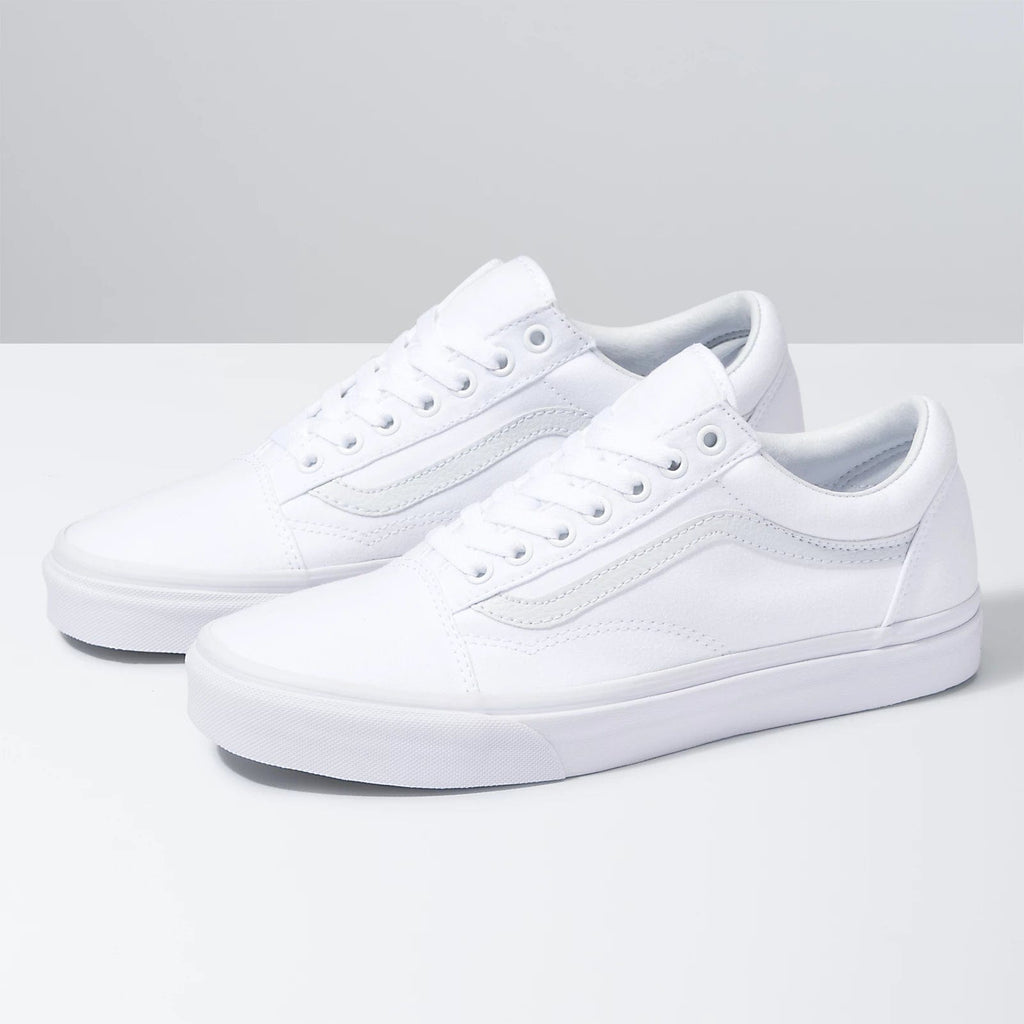 Vans Classic Old Skool sneakers in all-white with canvas upper, suede overlays, tonal side stripe, and lace-up closure, side angle view.