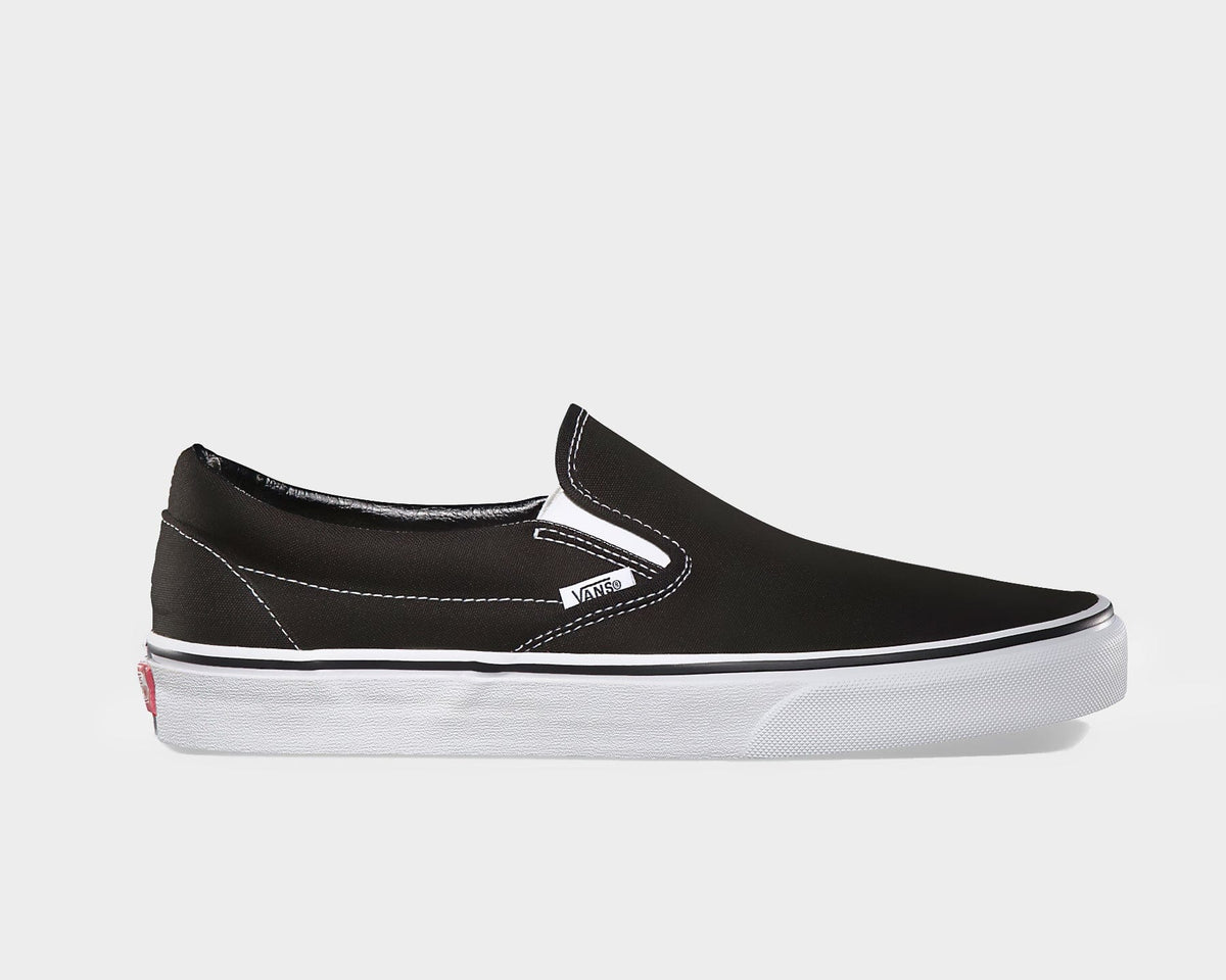 Vans Classic Slip On shoes in black canvas with white stitching, elastic side accents, and white rubber sole, side view.