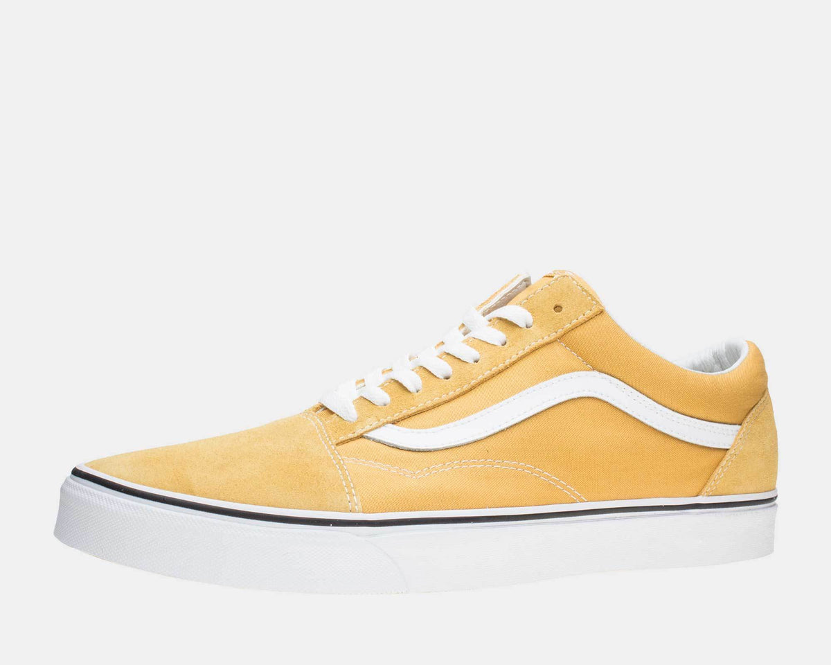 Vans Old Skool sneakers in mustard yellow with white side stripe, canvas and suede upper, and white rubber sole, side view.