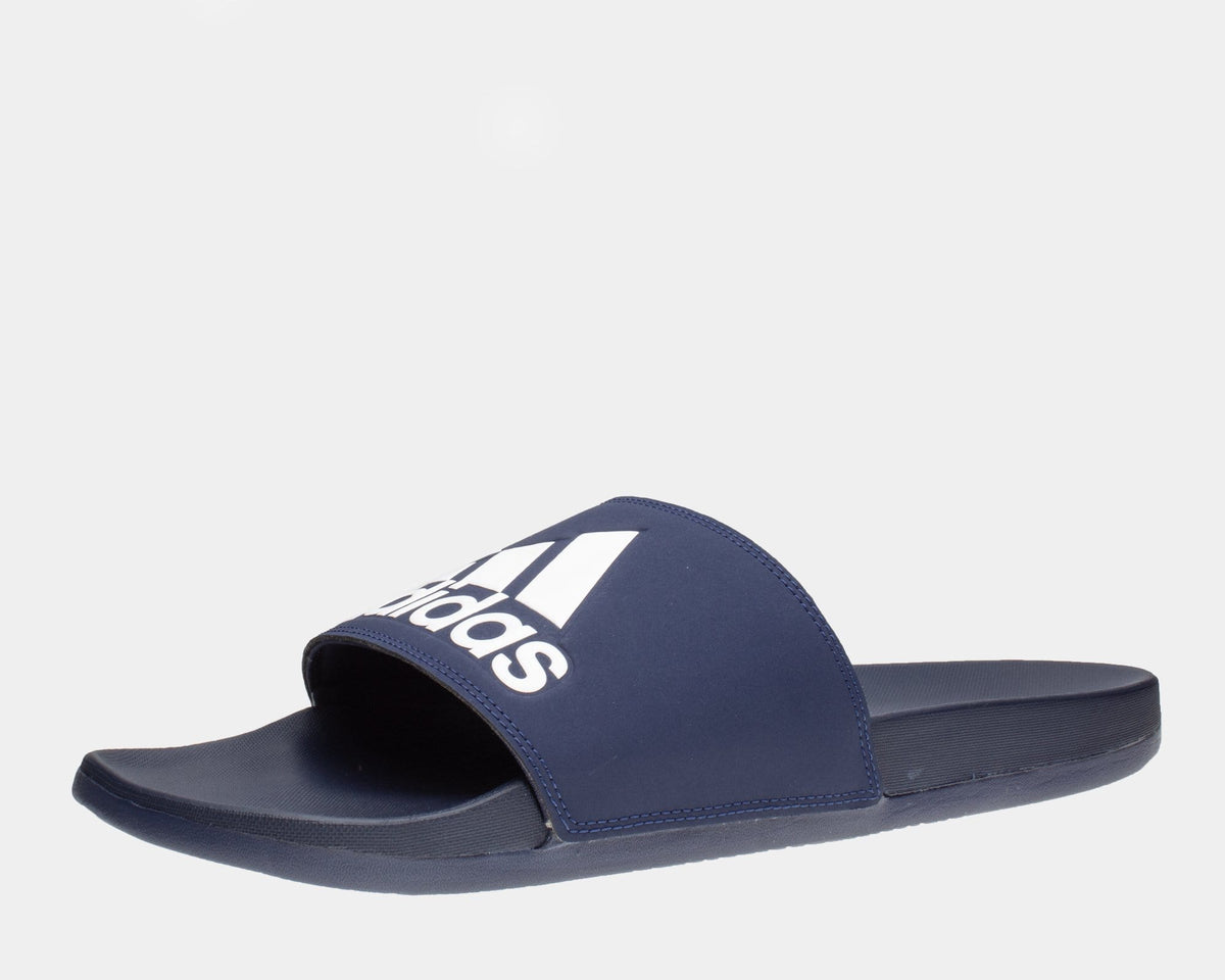 Adidas Adilette Comfort Slides in navy blue with white logo, cushioned footbed and slip-on design, side angle view