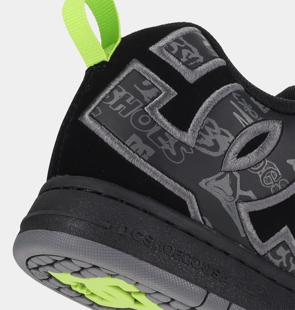 "DC Footwear Court Graffik shoes in black with bold gray logo detailing, graffiti-inspired graphics, and neon green pull tab, side and heel view"